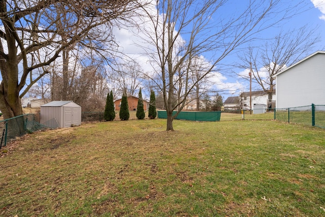 view of yard with a storage unit, an outdoor structure, and a fenced backyard