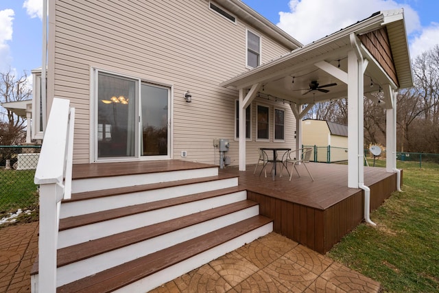 deck with a yard, fence, and a ceiling fan