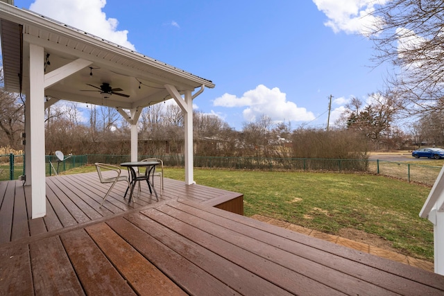 deck with a fenced backyard, ceiling fan, and a yard