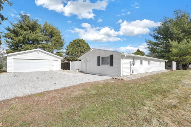 view of home's exterior with an outbuilding, a yard, a detached garage, and fence