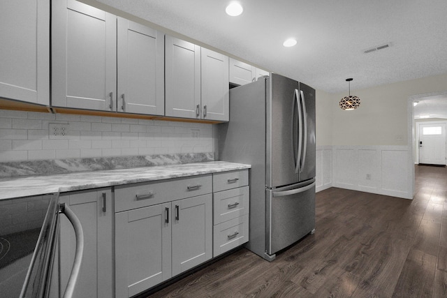 kitchen featuring freestanding refrigerator, dark wood-style flooring, wainscoting, and range