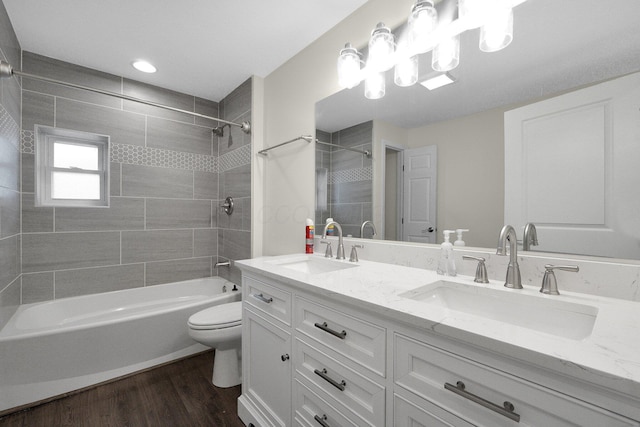 full bathroom featuring shower / bathtub combination, wood finished floors, a sink, and toilet