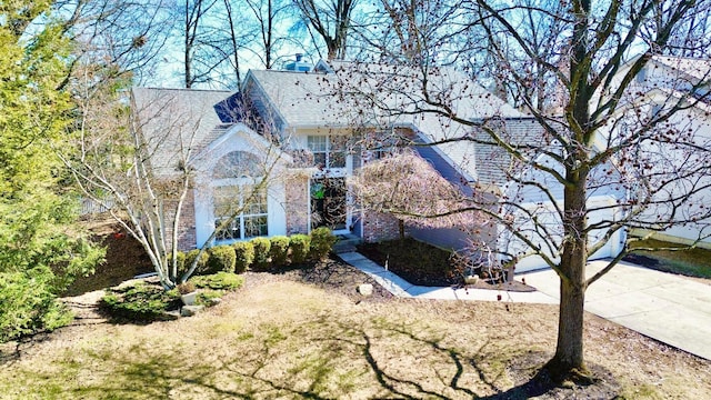 exterior space featuring a garage, concrete driveway, and brick siding