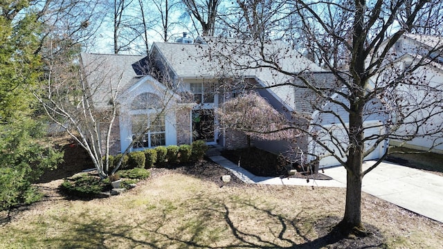 view of front facade featuring concrete driveway and brick siding