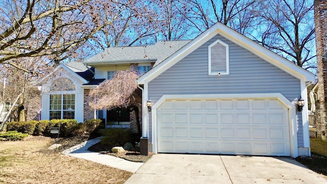 traditional-style house featuring a garage, driveway, and brick siding