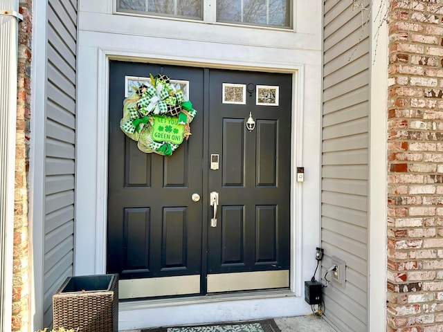 doorway to property featuring brick siding