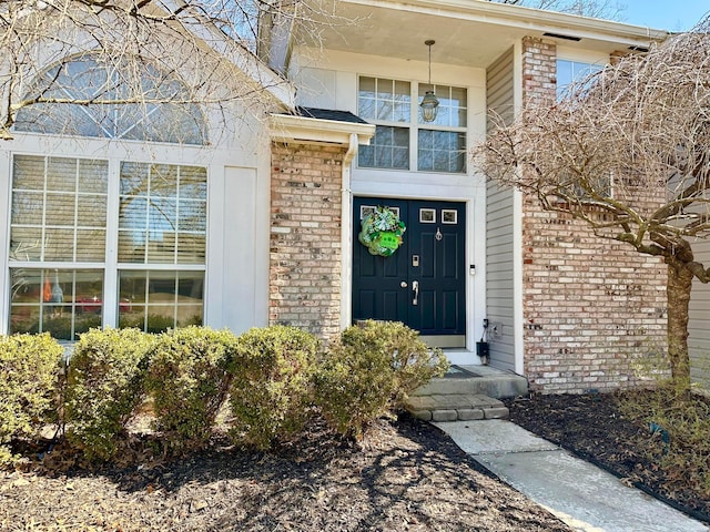 doorway to property featuring brick siding