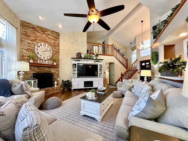 living room with plenty of natural light, wood finished floors, a fireplace, and stairs