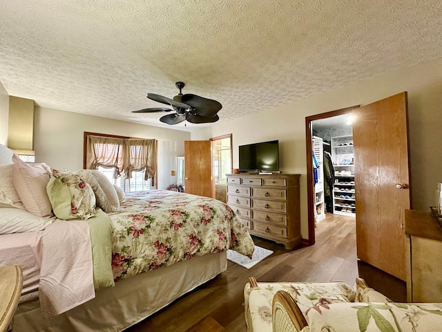 bedroom featuring ceiling fan, a textured ceiling, and wood finished floors