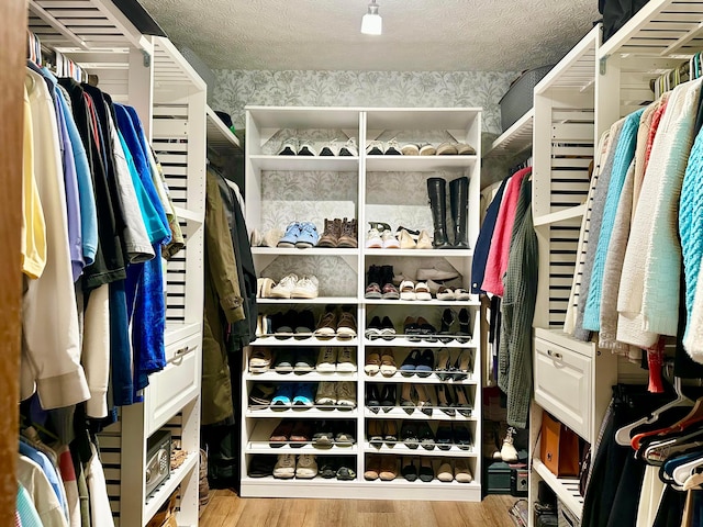 walk in closet with wood finished floors