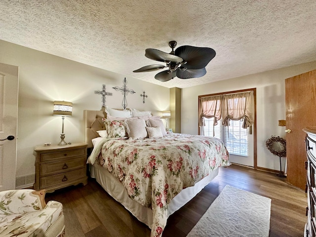 bedroom featuring dark wood-style floors, a textured ceiling, and a ceiling fan