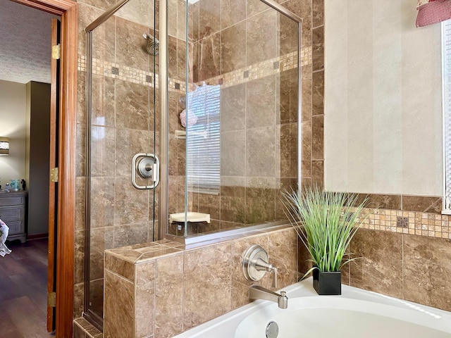 full bathroom with a stall shower and a textured ceiling