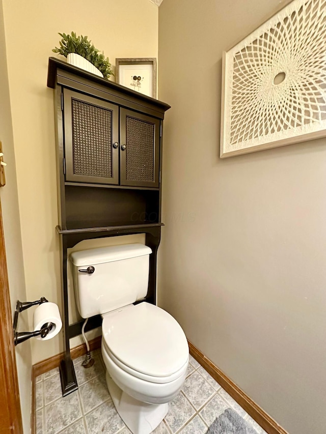 bathroom with toilet, tile patterned flooring, and baseboards