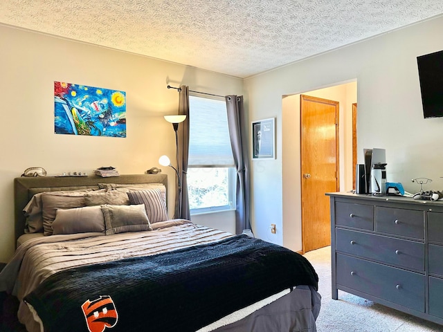 bedroom featuring a textured ceiling and light colored carpet