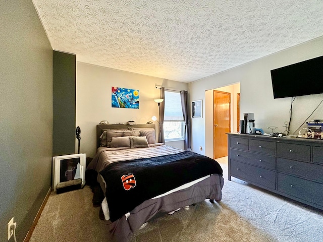 bedroom with a textured ceiling, connected bathroom, and light colored carpet