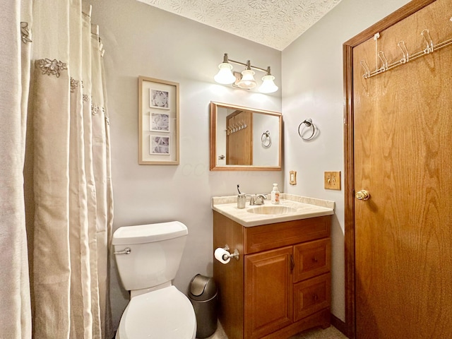 bathroom featuring a textured ceiling, toilet, and vanity