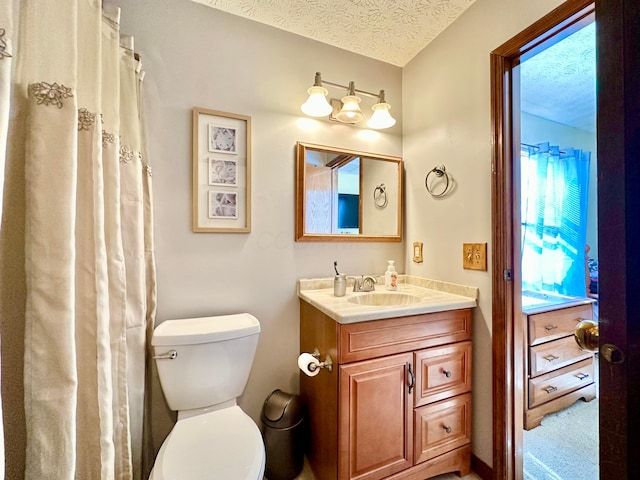 bathroom with toilet, a textured ceiling, and vanity