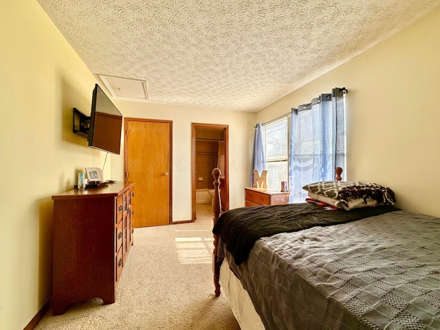 bedroom with light carpet, a textured ceiling, and baseboards