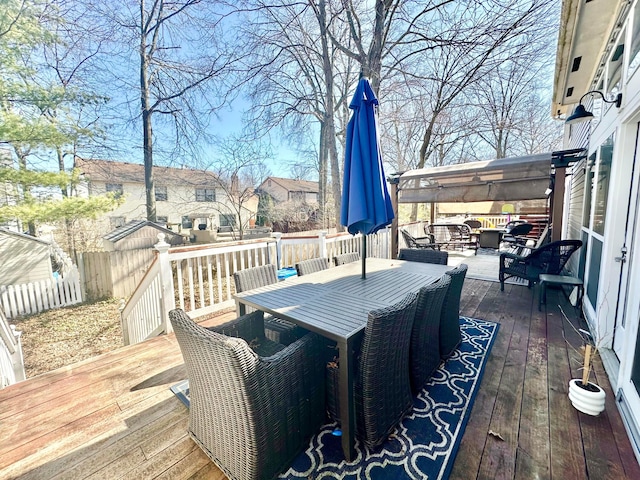 wooden deck with outdoor dining area, fence, and an outdoor living space