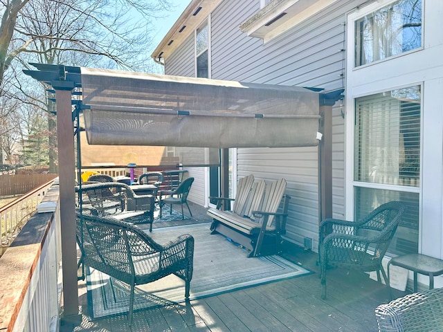 wooden terrace featuring fence and outdoor dining space