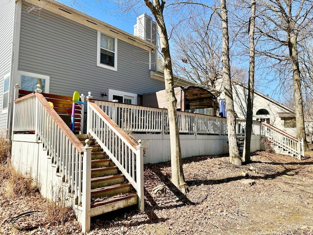 rear view of property with a chimney, stairway, and a wooden deck