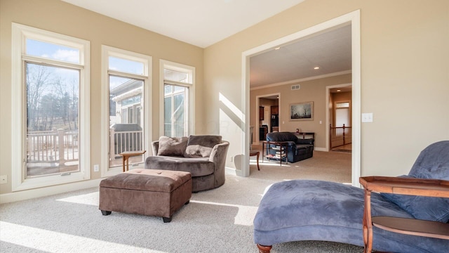 living room featuring crown molding, carpet flooring, baseboards, and plenty of natural light