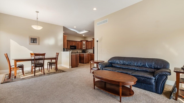 living area featuring recessed lighting, baseboards, visible vents, and light carpet