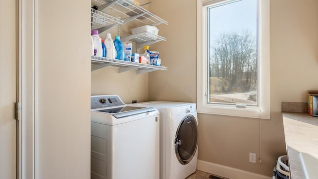 laundry area featuring washer and dryer, baseboards, and laundry area
