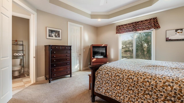bedroom with a raised ceiling, ensuite bathroom, crown molding, baseboards, and light colored carpet