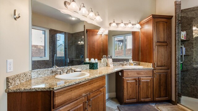 full bath with a sink, a stall shower, double vanity, and tile patterned flooring