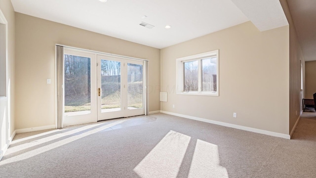 carpeted spare room featuring a wealth of natural light, visible vents, baseboards, and recessed lighting