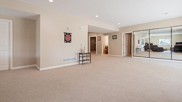 spare room with recessed lighting, visible vents, light carpet, and baseboards