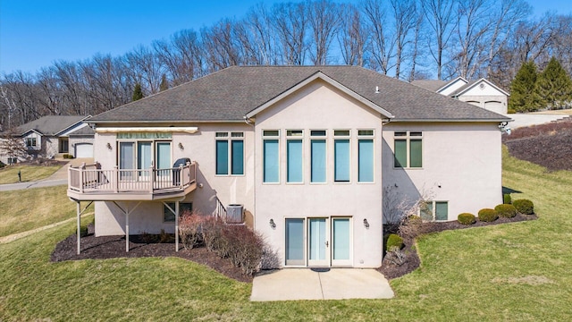 rear view of house with stucco siding, a lawn, central AC unit, and french doors