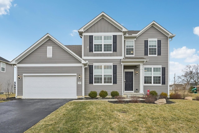 traditional-style house with board and batten siding, a garage, driveway, and a front lawn