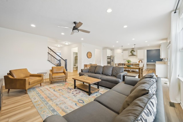 living room with recessed lighting, visible vents, stairway, ceiling fan, and light wood-type flooring