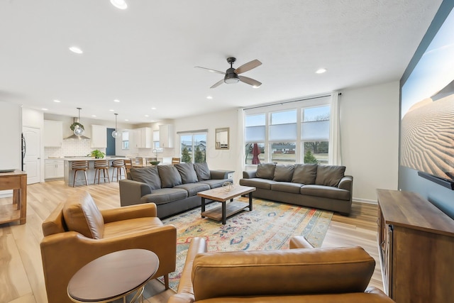 living room with a ceiling fan, recessed lighting, and light wood finished floors