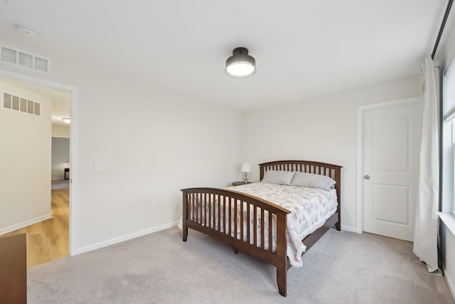 bedroom featuring light carpet, visible vents, and baseboards