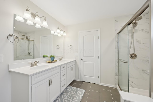 full bathroom with tile patterned flooring, a sink, a marble finish shower, and double vanity