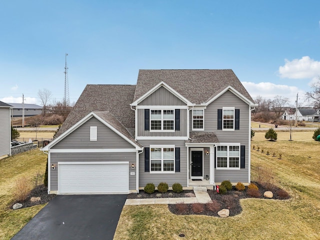 traditional-style house featuring an attached garage, a shingled roof, driveway, a front lawn, and board and batten siding