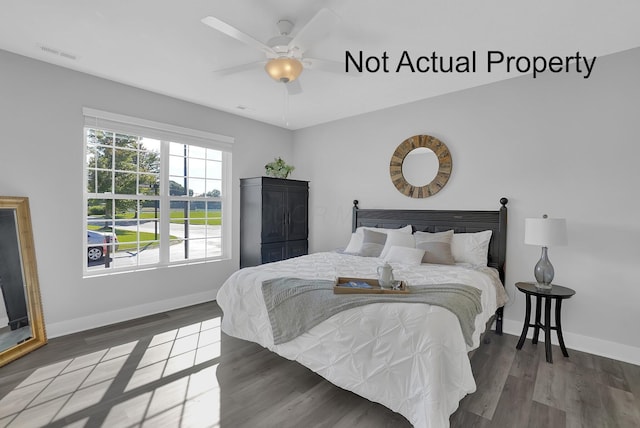 bedroom featuring a ceiling fan, wood finished floors, visible vents, and baseboards