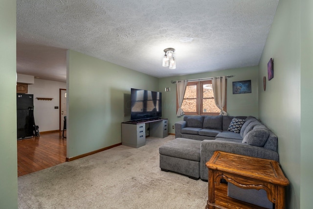 living area featuring baseboards, a textured ceiling, and light colored carpet