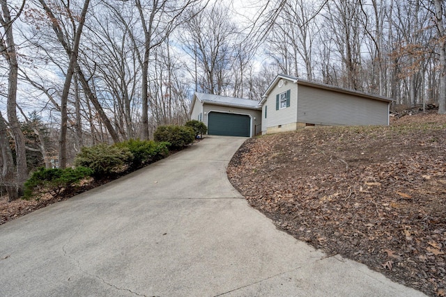 view of home's exterior featuring metal roof, concrete driveway, crawl space, and an attached garage