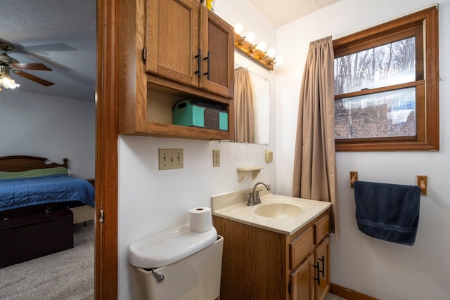 bathroom featuring toilet, ensuite bath, vanity, and a ceiling fan