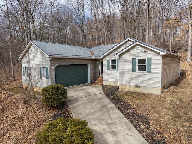 ranch-style home featuring a garage, metal roof, crawl space, and driveway