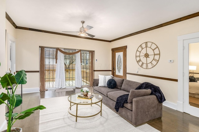 living room featuring ornamental molding, ceiling fan, baseboards, and wood finished floors