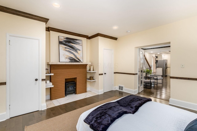 bedroom with freestanding refrigerator, visible vents, recessed lighting, and wood finished floors