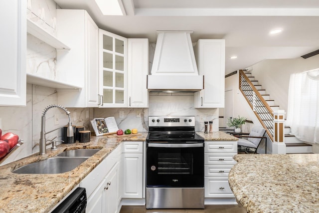 kitchen featuring stainless steel electric range, a sink, white cabinetry, and custom range hood