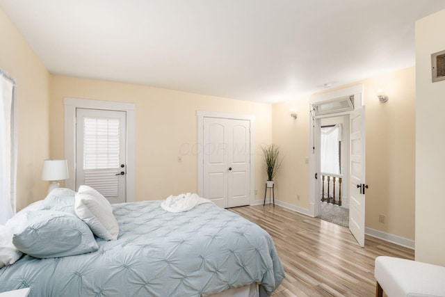 bedroom featuring light wood-type flooring, visible vents, and baseboards