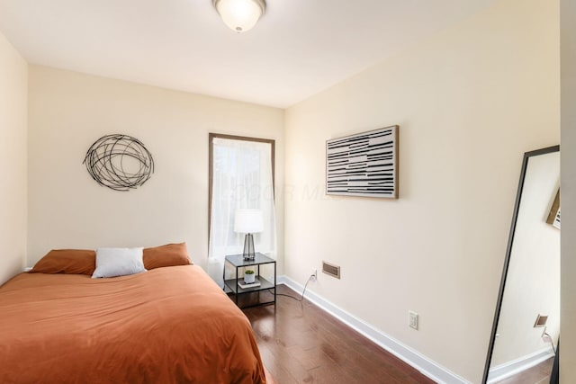 bedroom featuring dark wood-style floors and baseboards