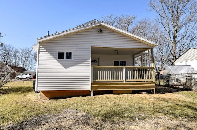 back of house with a lawn and a deck